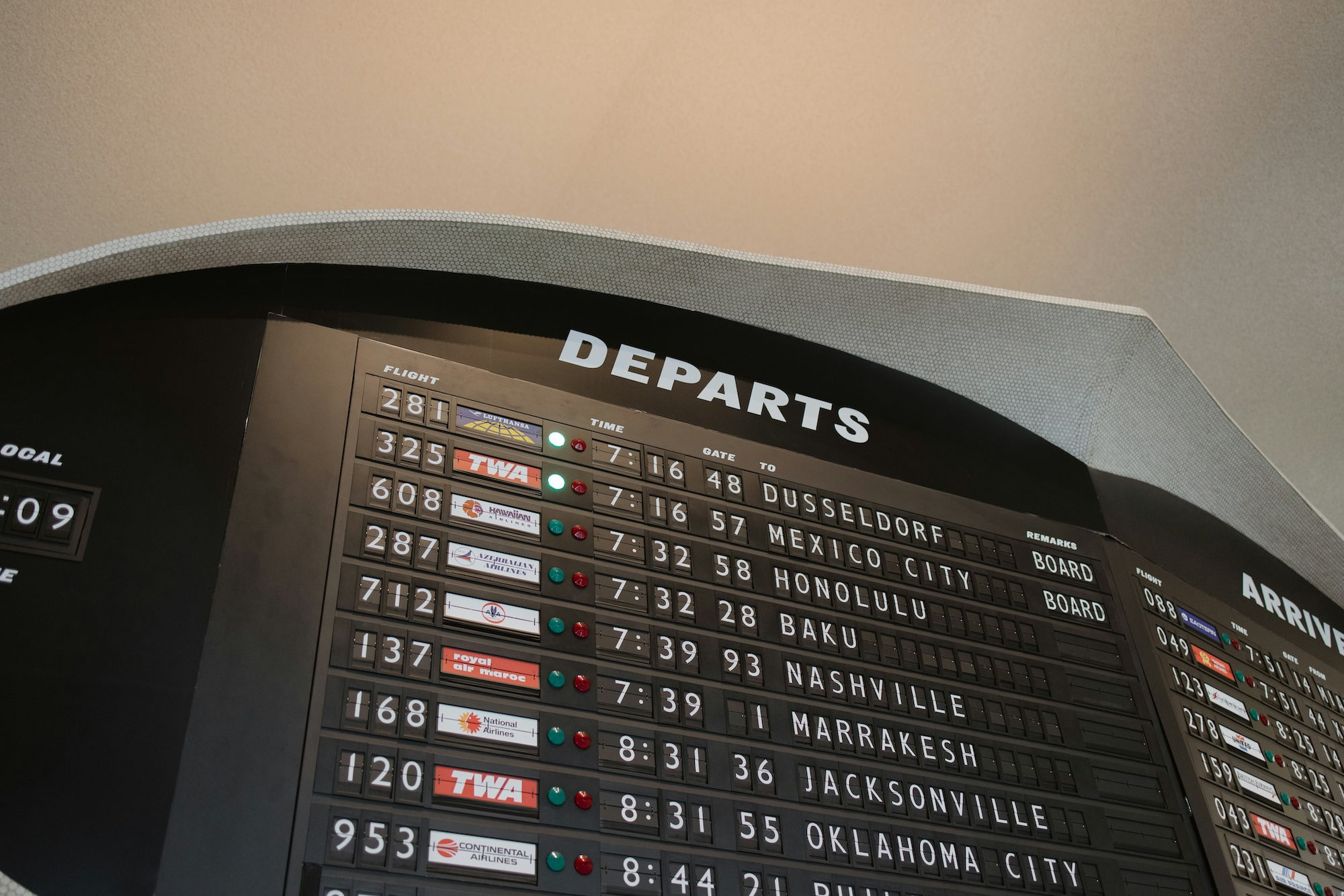 Vintage airport departures board showing flights to destinations worldwide