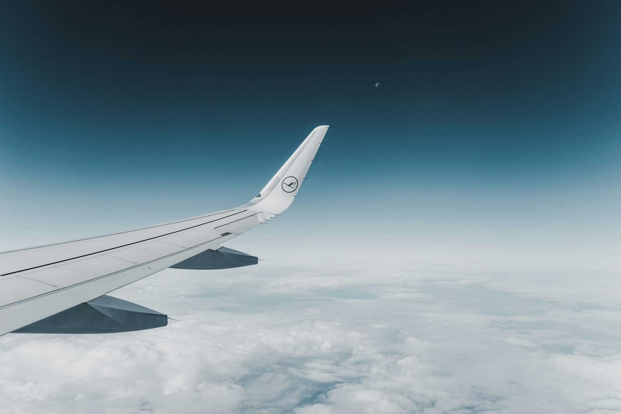 White and blue airplane wing seen from passenger window during flight
