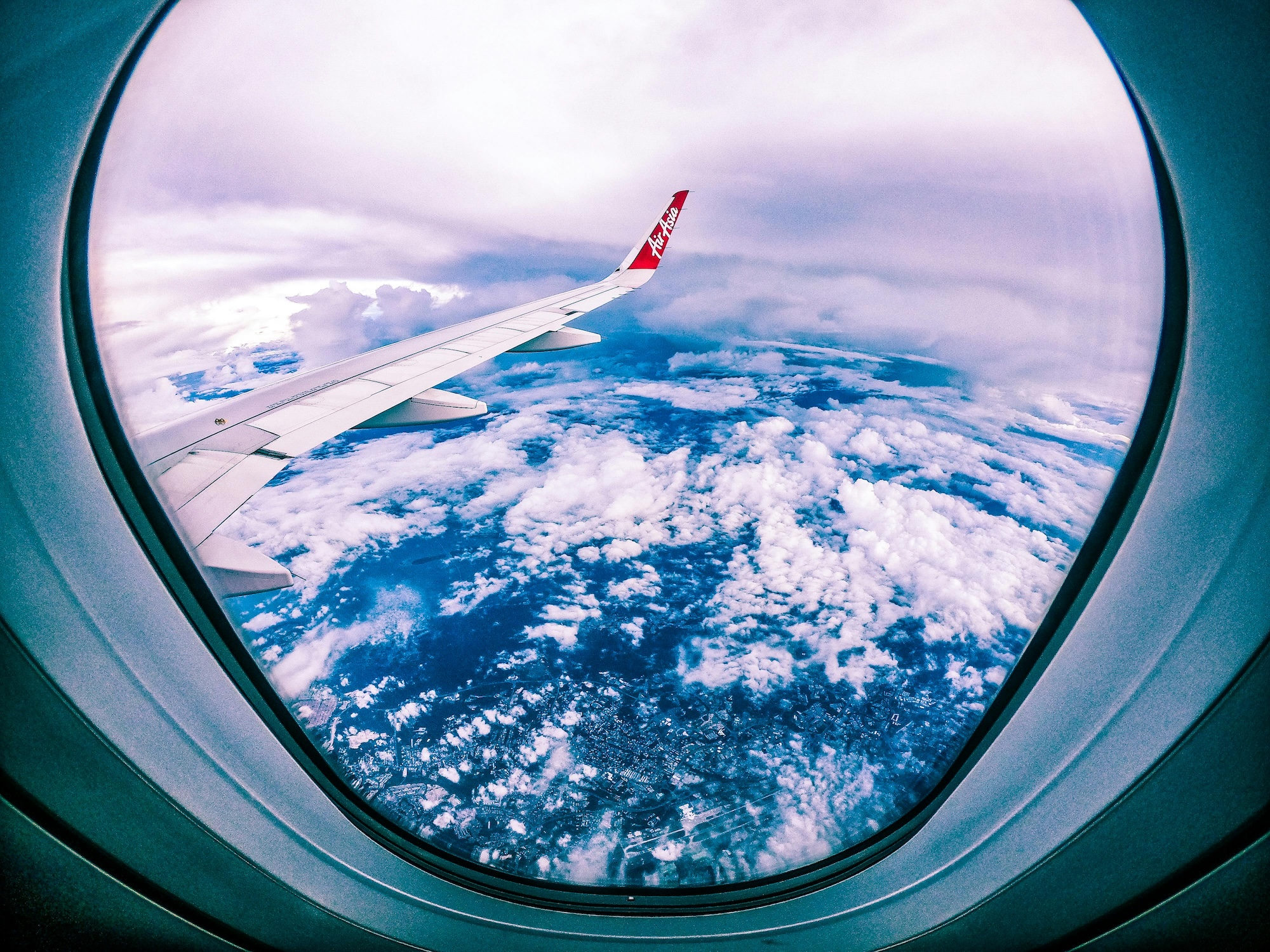 Clouds and airplane wing seen from plane window